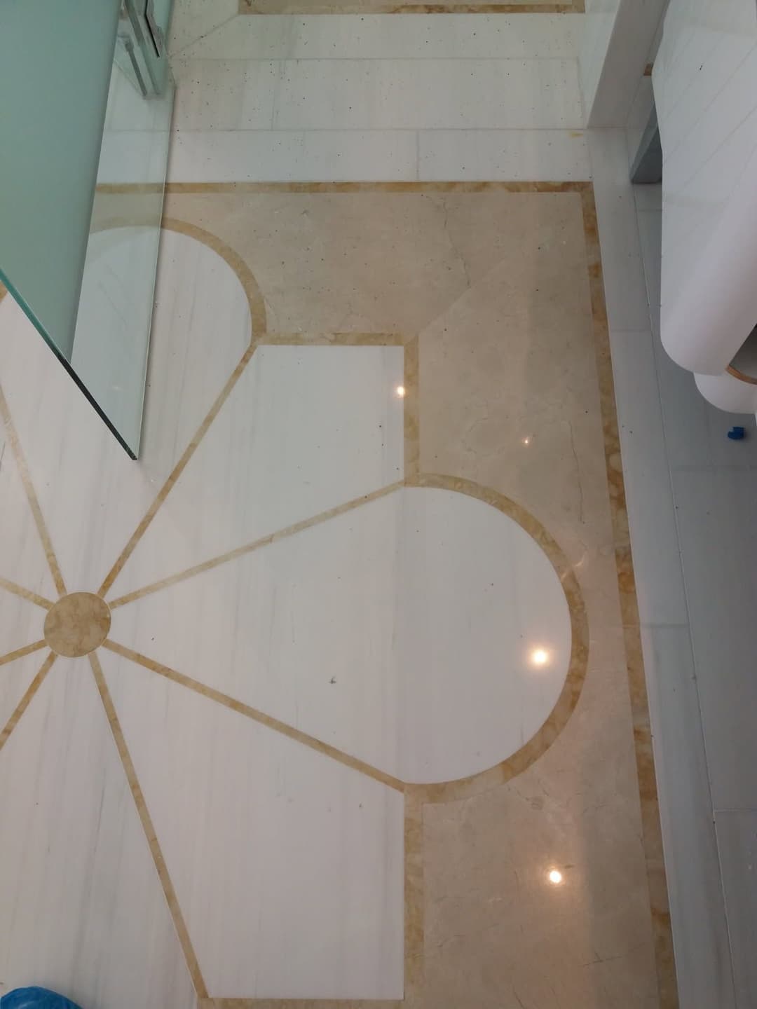 Elegant marble floor design with geometric patterns and light reflections.