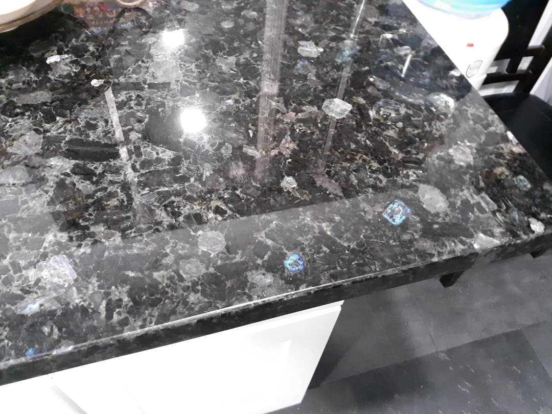 Black granite countertop featuring unique blue and silver mineral flecks. Modern kitchen design.