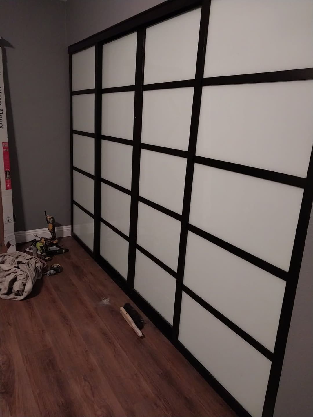 Modern black sliding door with frosted panels in a minimalist interior setting.